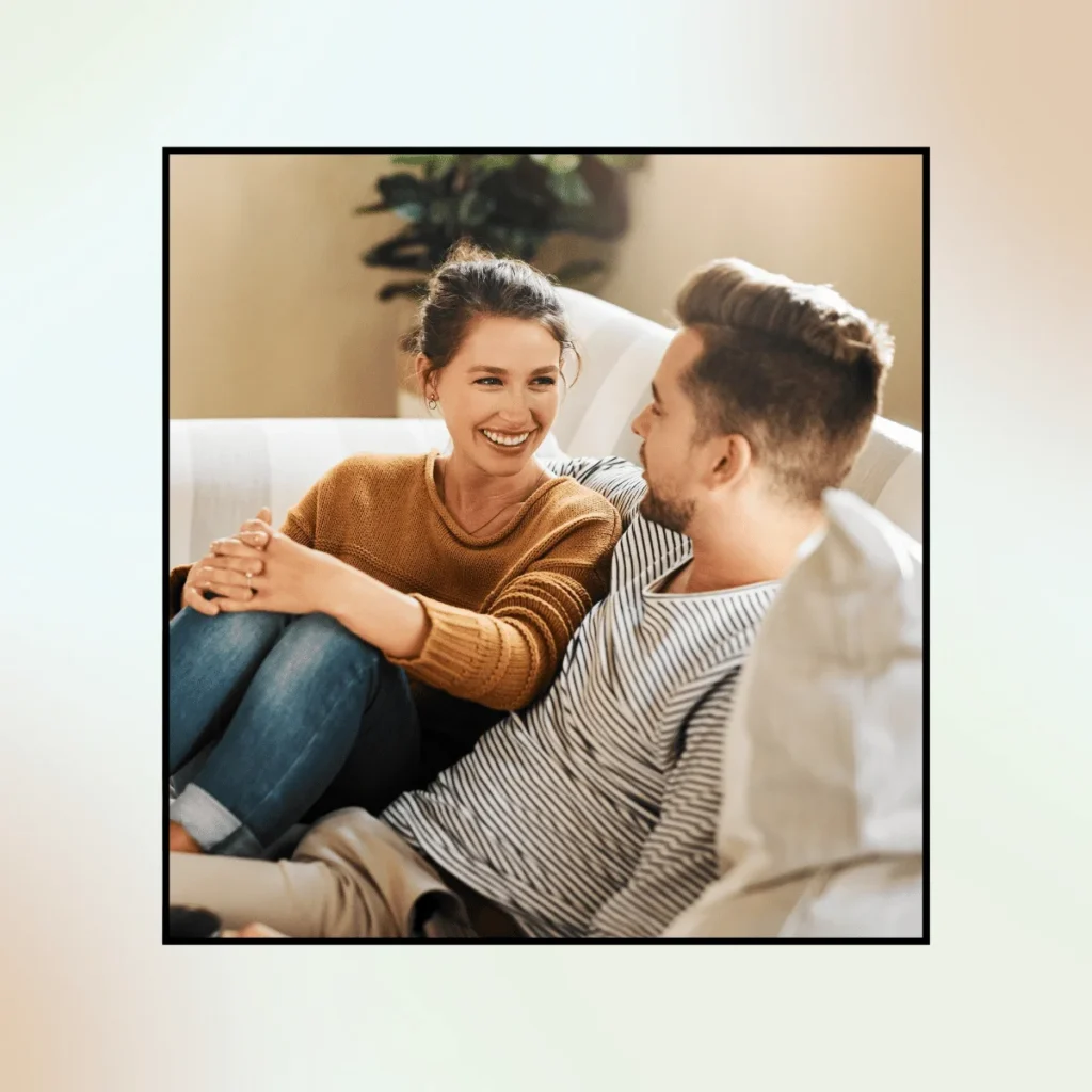 Happy couple talking on a couch. Affirmations For Manifesting Love