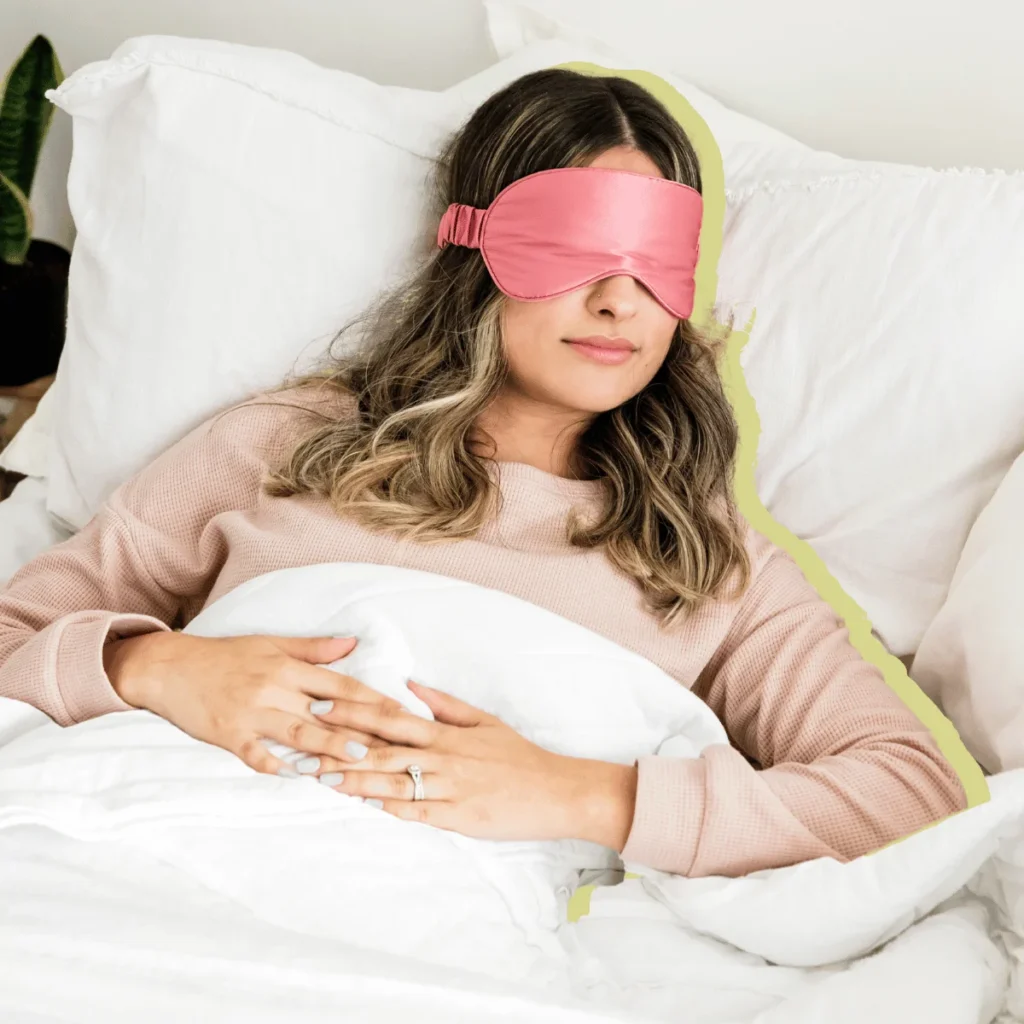 Woman sleeping in with a pink sleep mask