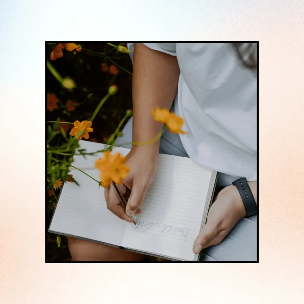 Woman writing in a notebook outdoors around nature. Scripting Manifestation Technique