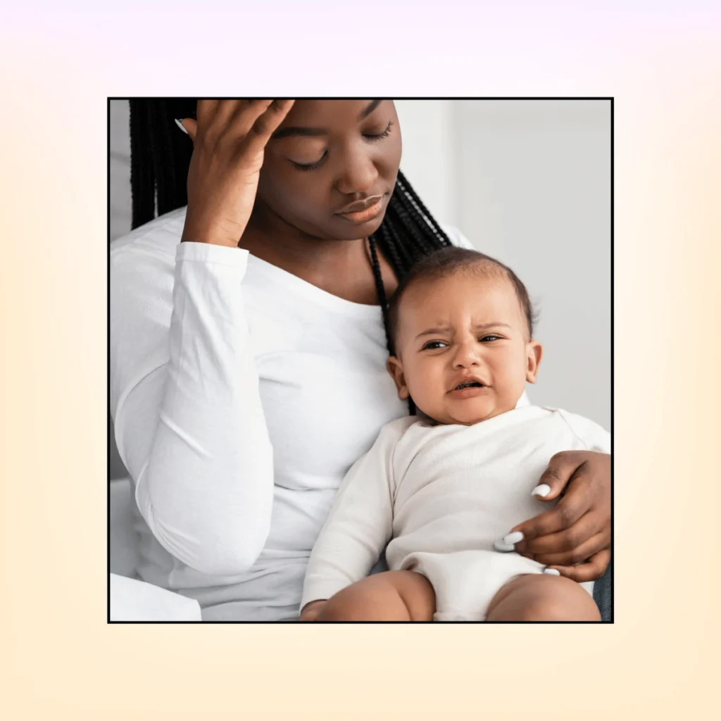 Stressed African American mom sitting with her child on bed