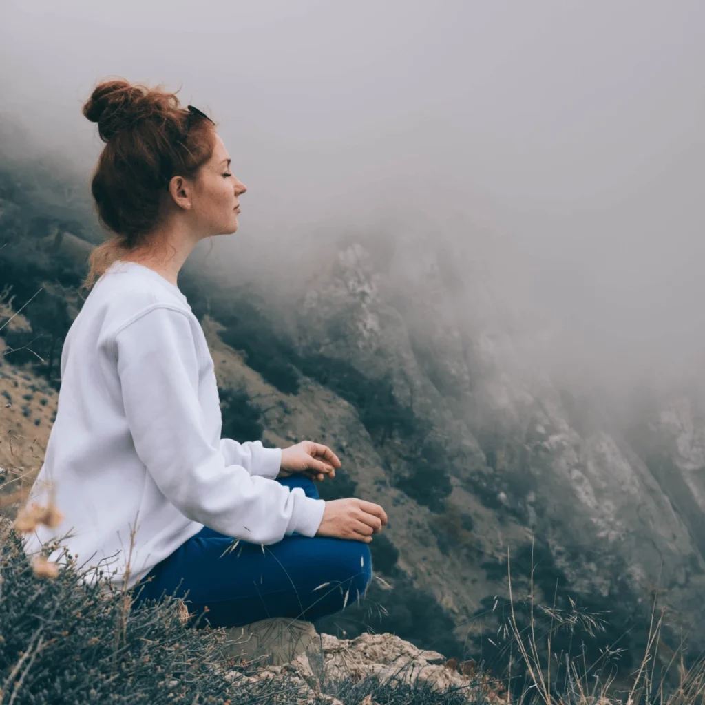 Woman meditating in the mountains