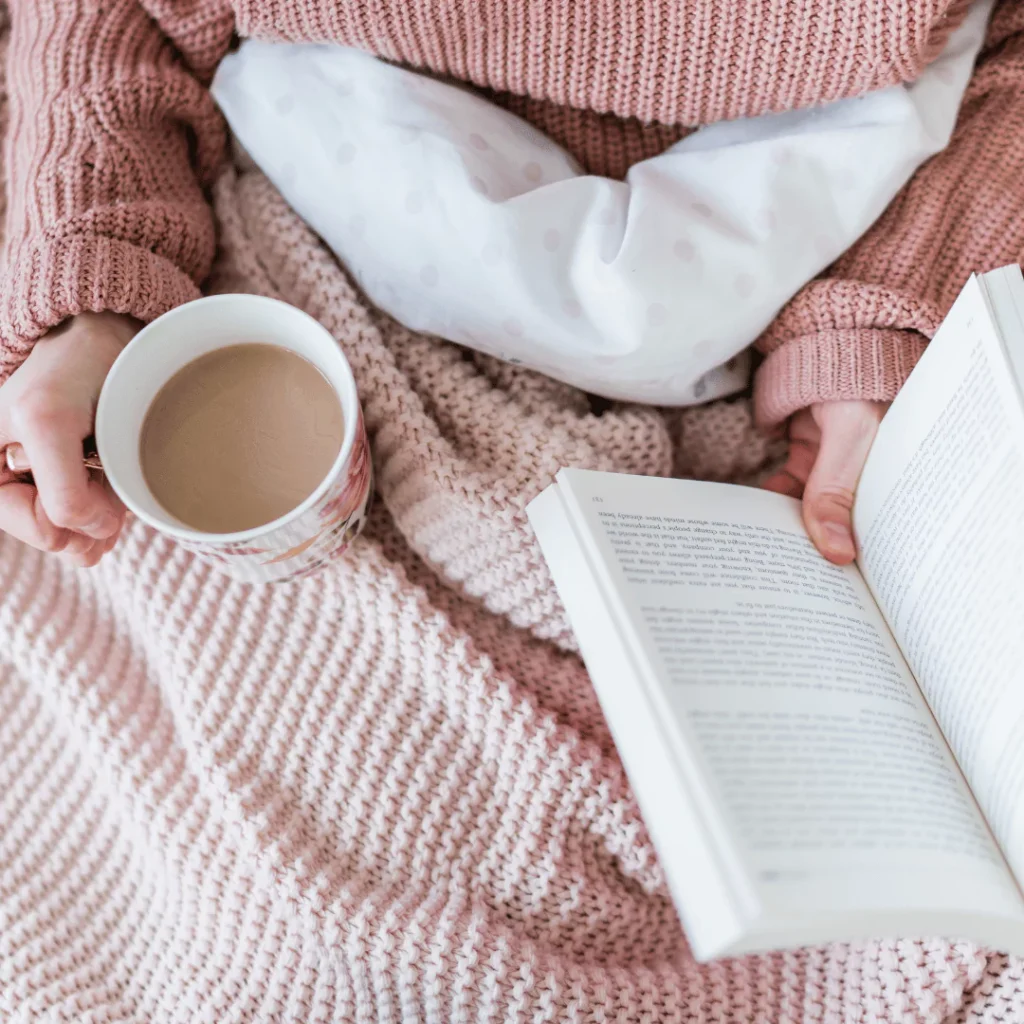 woman reading in bed with a cup of coffee Sunday self-care quotes