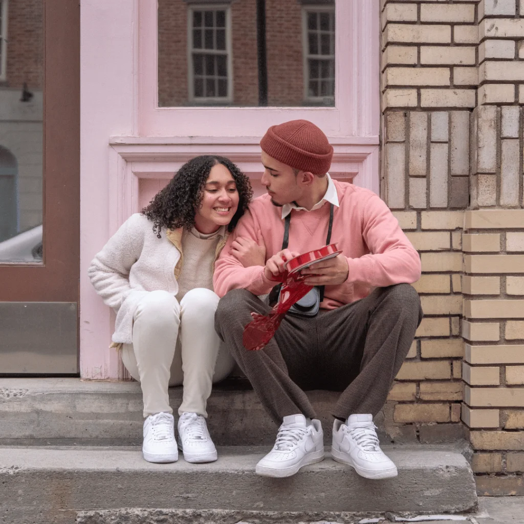 Happy-ethnic-woman-cuddling-with-boyfriend-presenting-gift-box-on-Saint-Valentines-Day.-