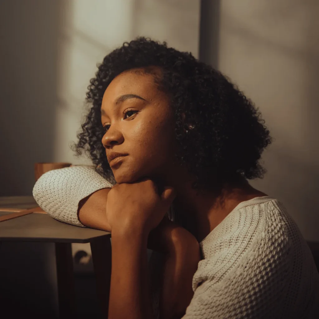 Lonely woman sitting in a room with some light coming in