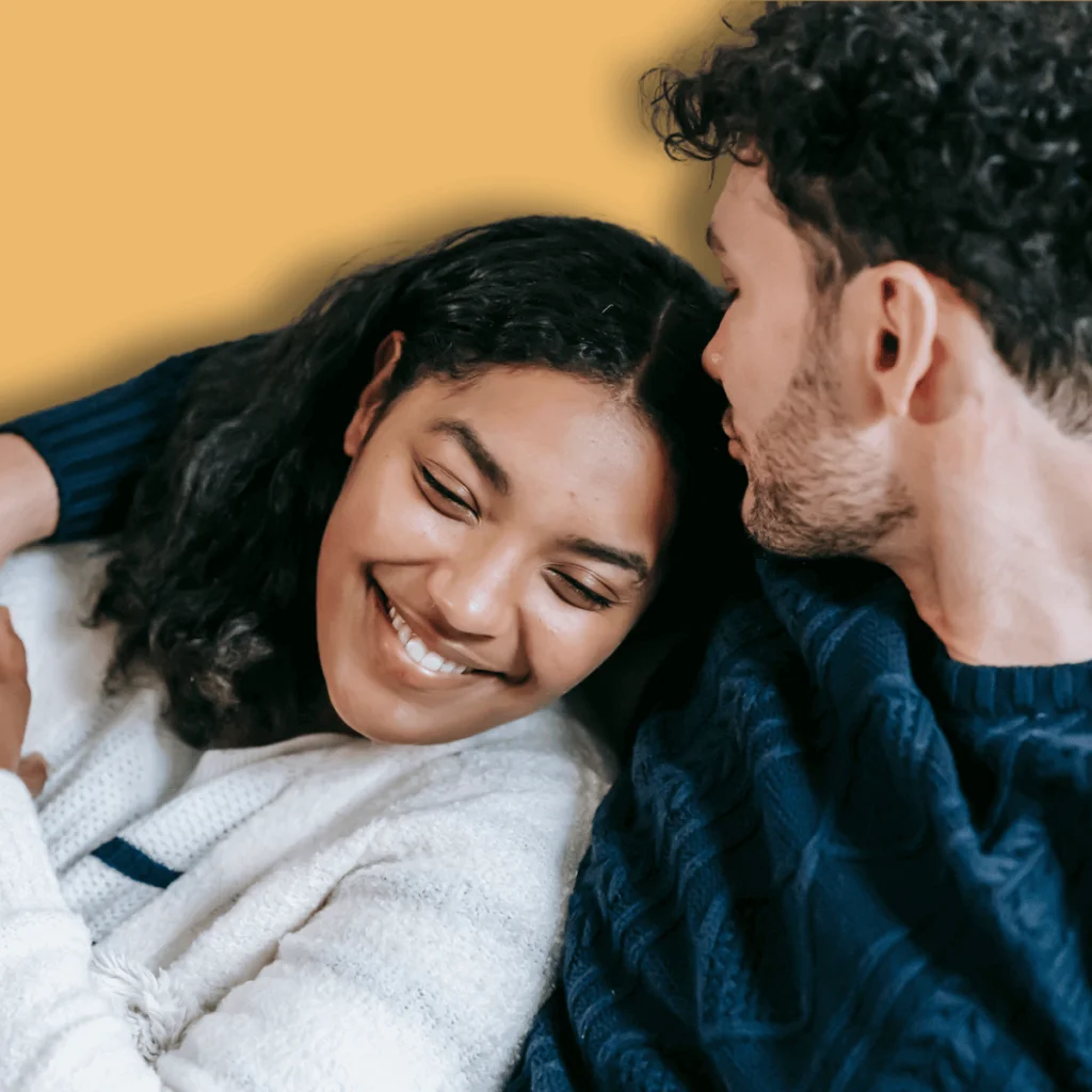 Smiling-loving-multiethnic-couple-cuddling-on-couch.