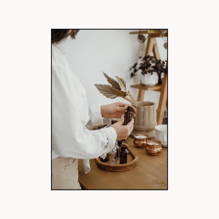 Woman Preparing Bottles of Scented Oil for Candle Making