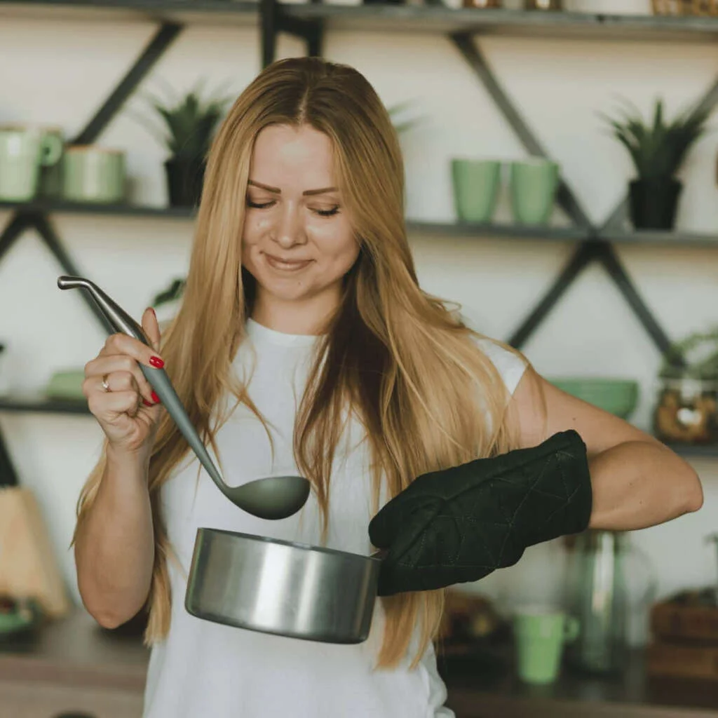 Woman holding up a pot of food. Self-Care Sundays