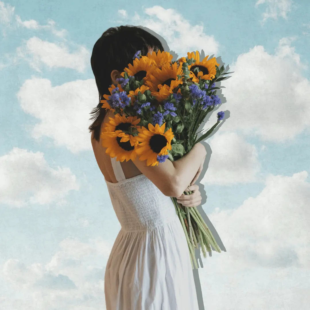 Woman in a white dress holding sunflowers