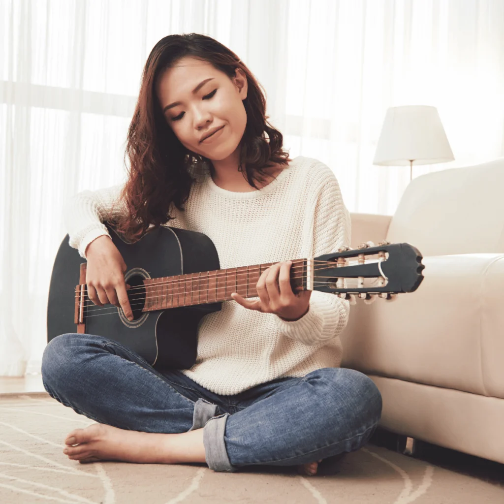 Woman-playing-the-guitar-at-home.-100-Solo-Date-Ideas