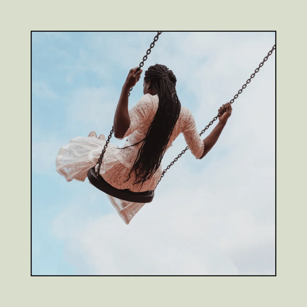 Woman-with-braids-swinging-on-a-swing.-100-Solo-Date-Ideas