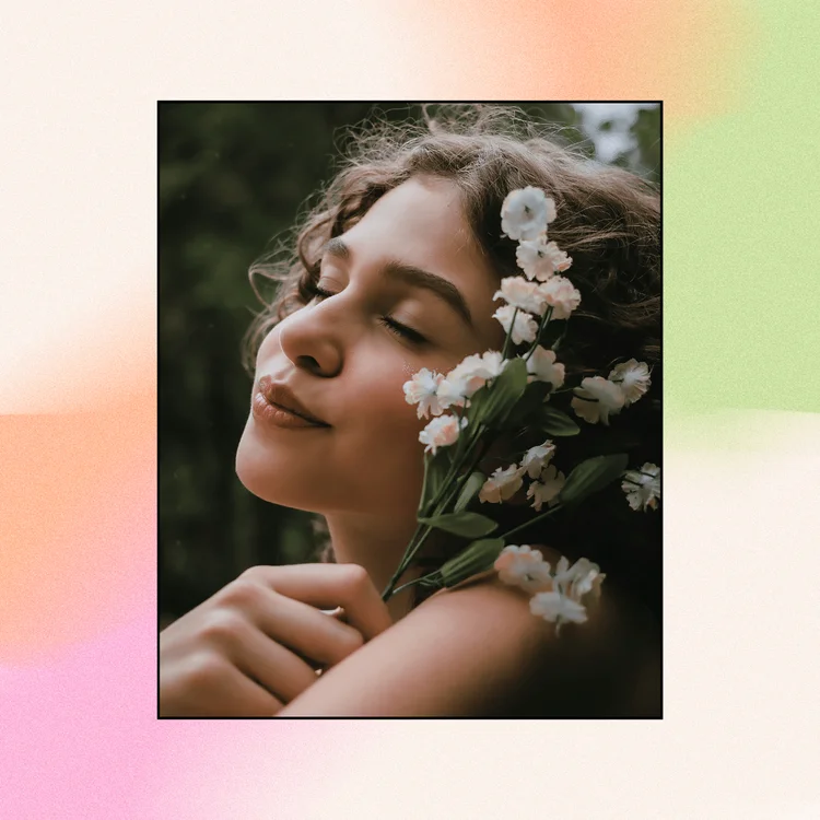 Woman with flowers near her face closed eyes in nature.